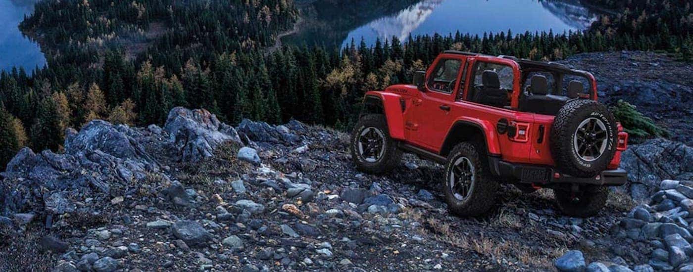 A red 2025 Jeep Wrangler off-roading.