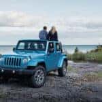 A couple on a blue 2017 Jeep Wrangler Unlimited Rubicon.