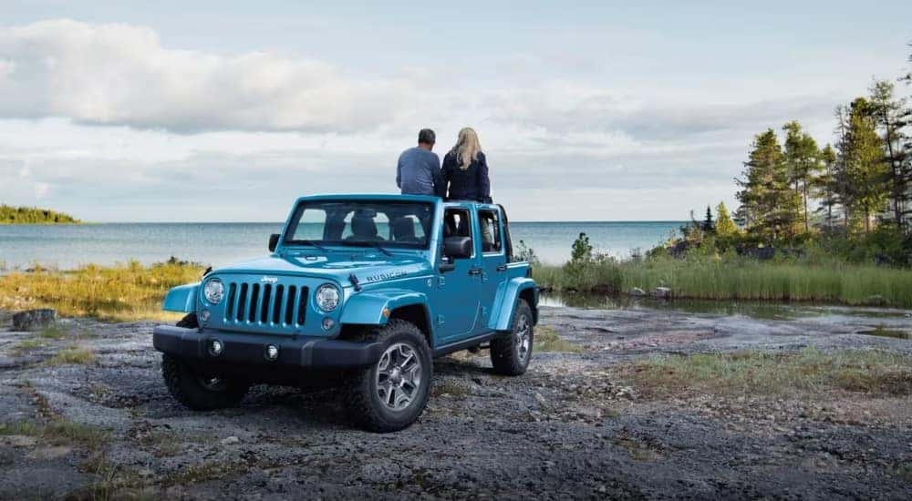 A couple on a blue 2017 Jeep Wrangler Unlimited Rubicon.