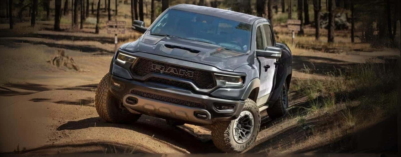 A black 2024 Ram 1500 TRX is parked off-road.