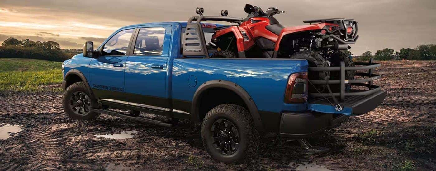 A blue 2024 Ram 2500 Power Wagon is parked on a muddy field.