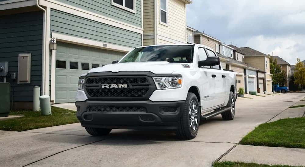 A white 2021 Ram 1500 parked near a garage.