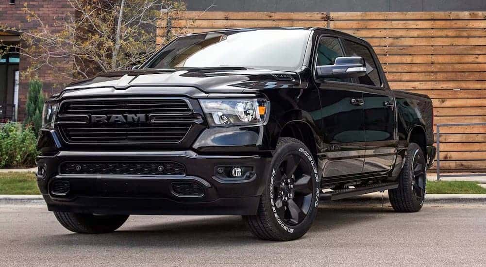 A black 2024 Ram 1500 DT parked near a curb.