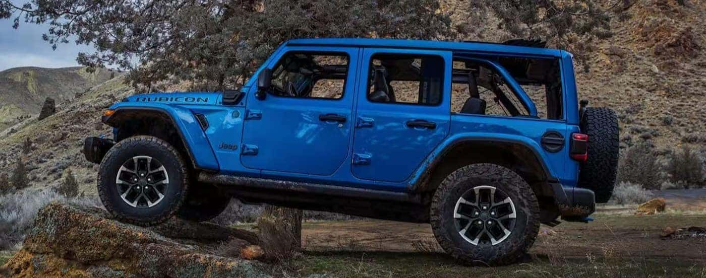 A blue 2025 Jeep Wrangler Rubicon off-roading.