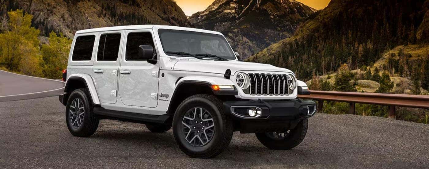 A white 2025 Jeep Wrangler for sale near Denver parked off-road.