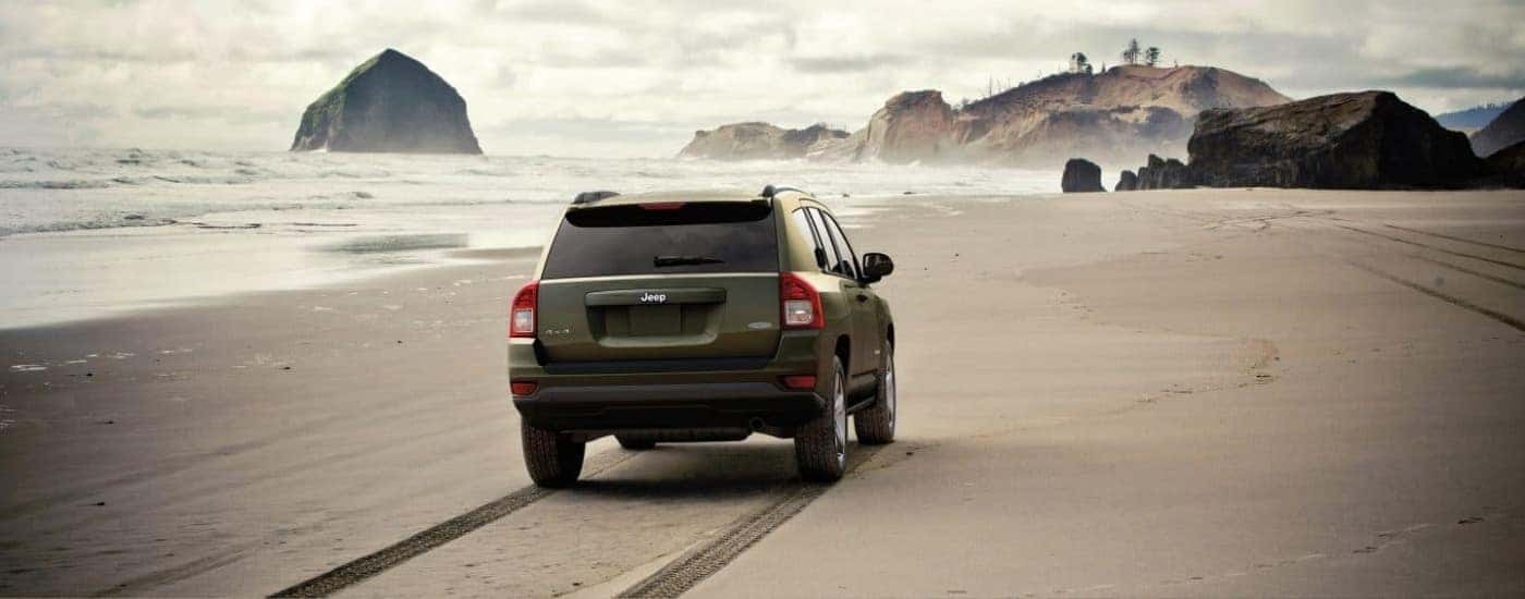 A green 2017 Jeep Compass Latitude driving to a Jeep dealer near Concord.