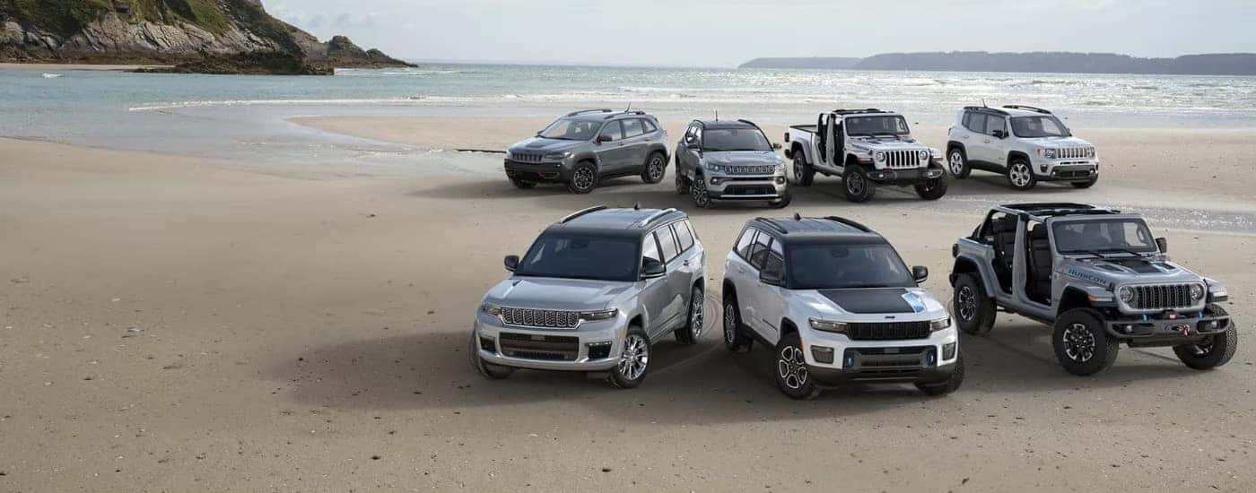 A lineup of 2023 Jeep models on a beach.