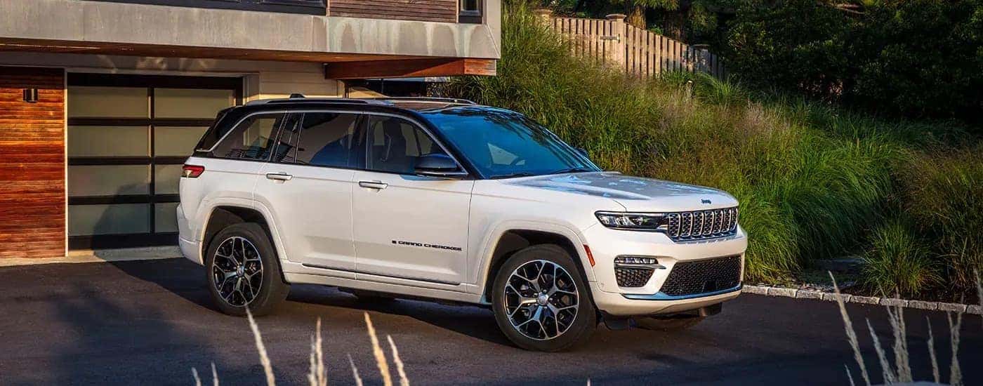 A white 2025 Jeep Grand Cherokee for sale near Denver in a driveway.