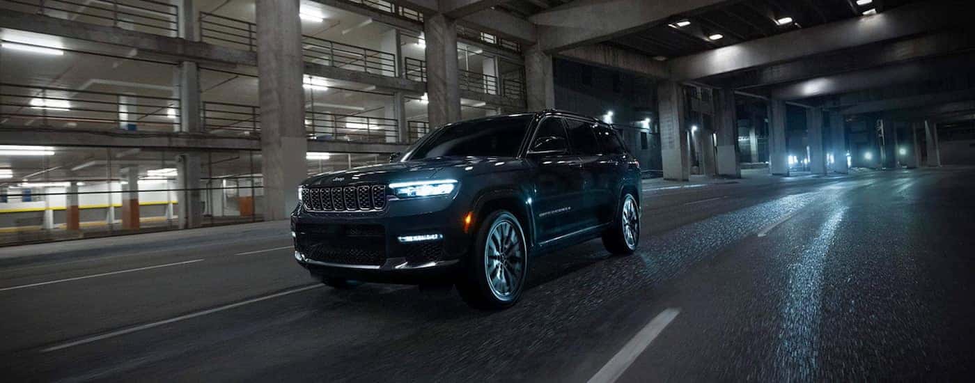 Black 2025 Jeep Grand Cherokee for sale in Cornelius driving through a city.