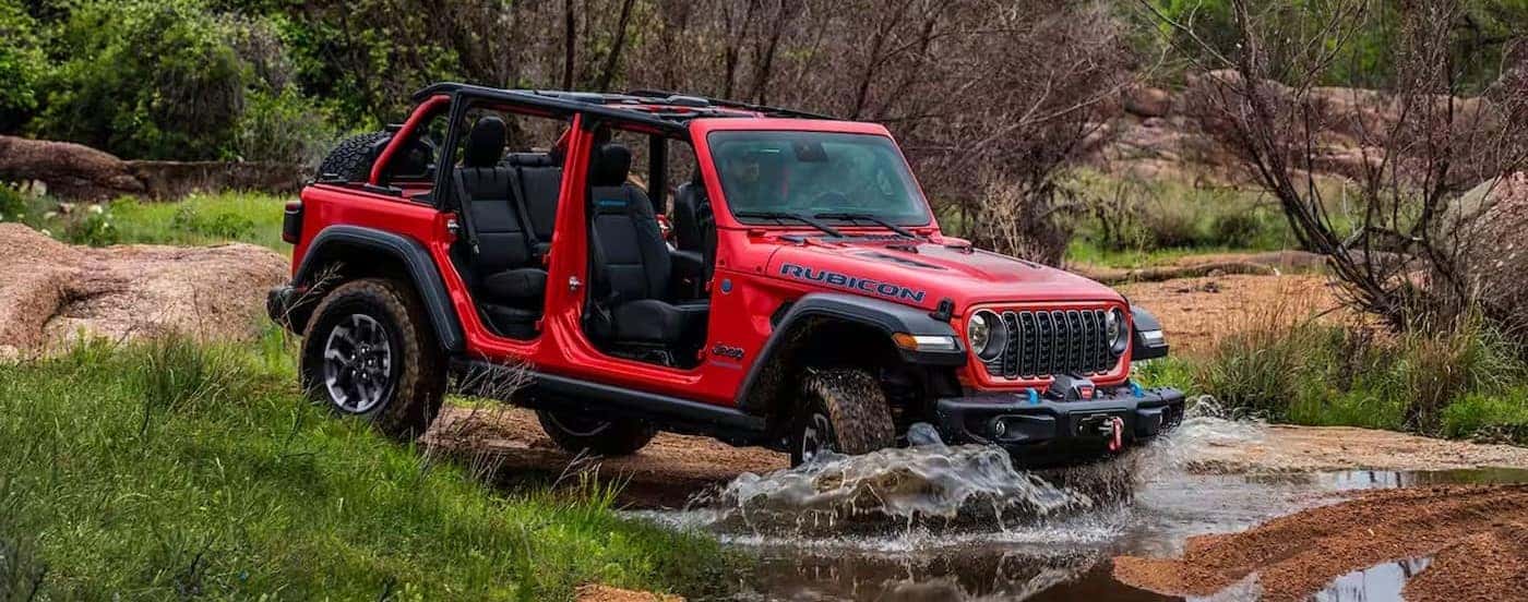 A red 2025 Jeep Wrangler Rubicon off-roading.