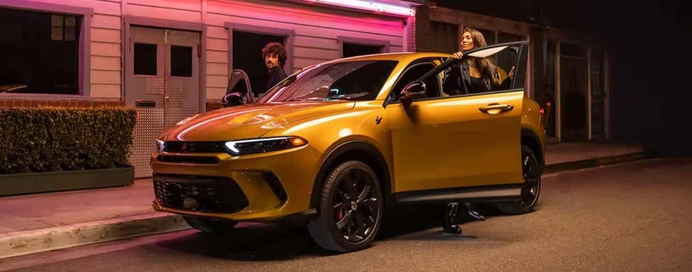 A yellow 2025 Dodge Hornet parked in a city.