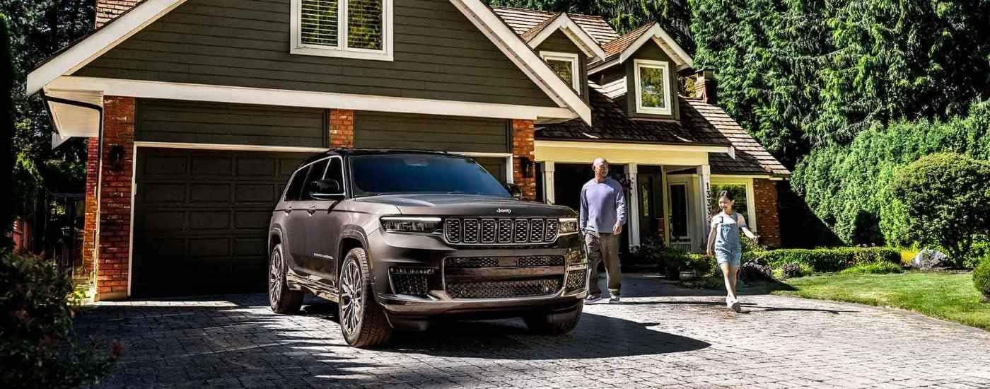 Grey 2025 Jeep Grand Cherokee parked in a driveway.