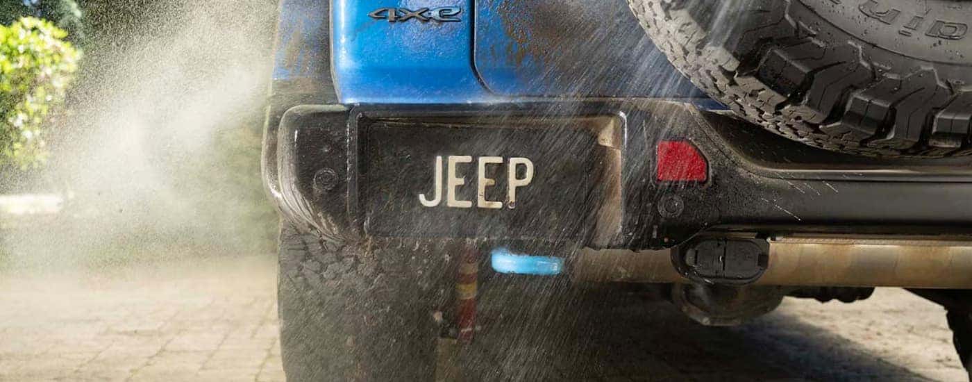 Muddy blue 2025 Jeep Wrangler 4xe being cleaned.