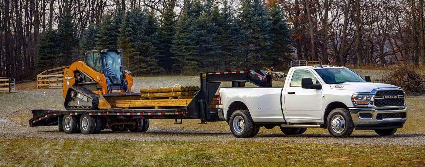 A white 2024 Ram 3500 towing a trailer after viewing a used Ram for sale near Statesville.