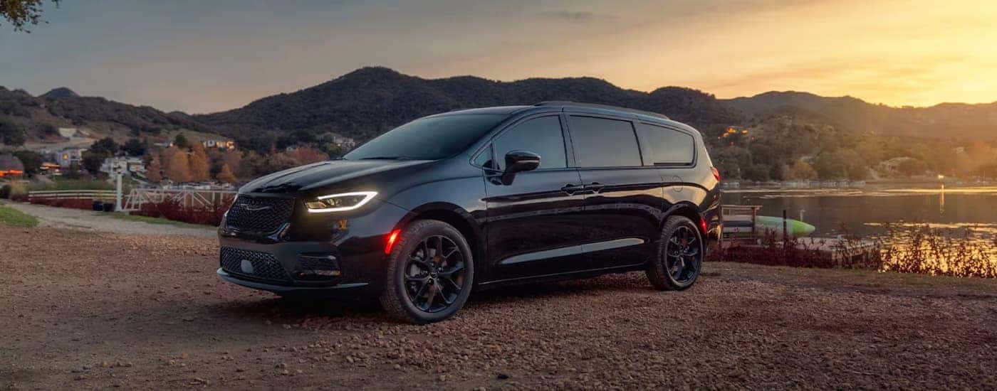 A black 2025 Chrysler Pacifica parked near a lake