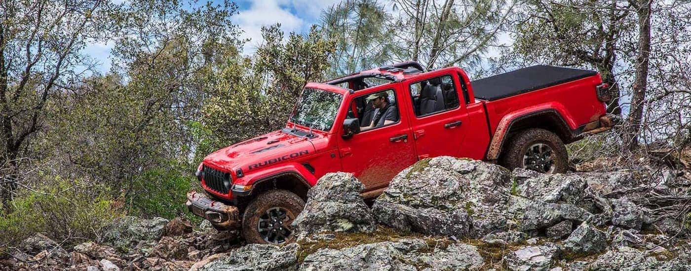 A red 2025 Jeep Gladiator off-road on rocky terrain