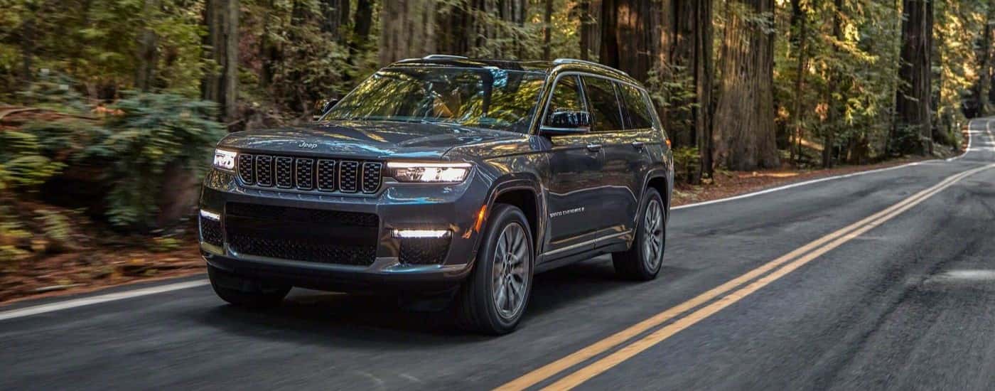 A gray 2021 Jeep Grand Cherokee L driving on a highway.