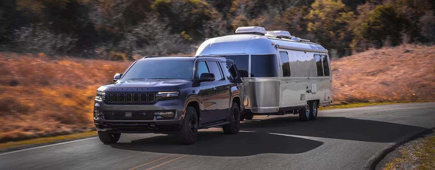A gray 2024 Jeep Wagoneer towing a trailer.