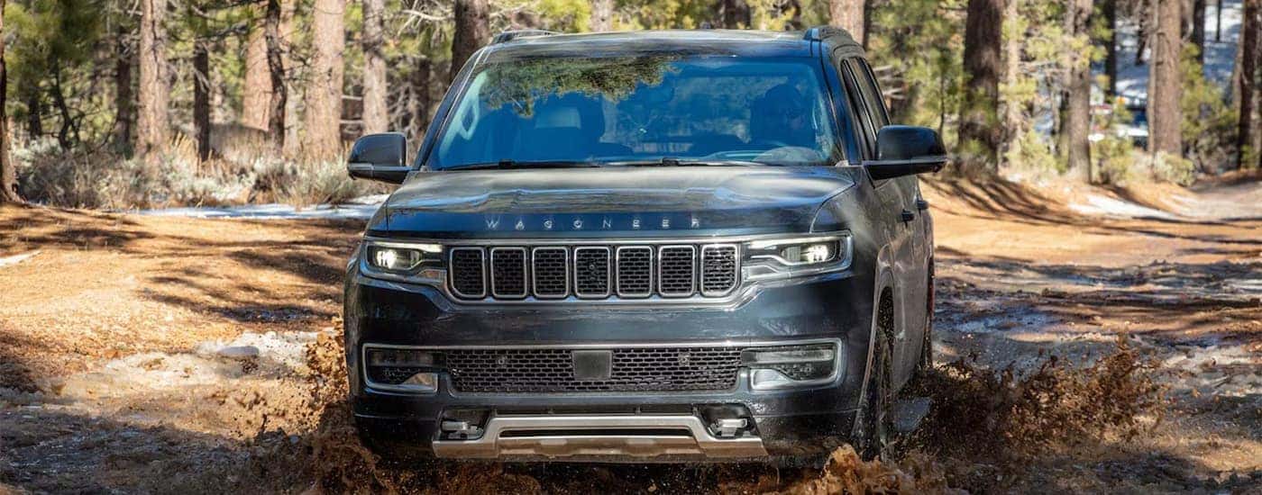 A gray 2025 Jeep Wagoneer driving off-road in mud