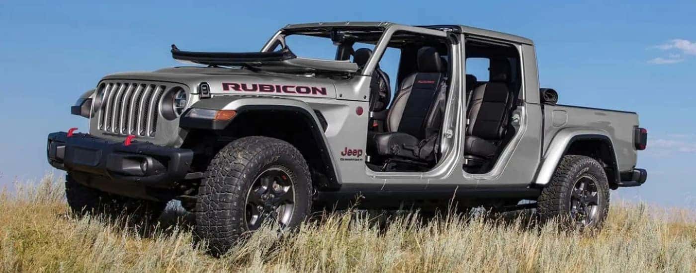 A silver 2023 Jeep Gladiator for sale near Mooresville parked on a field.