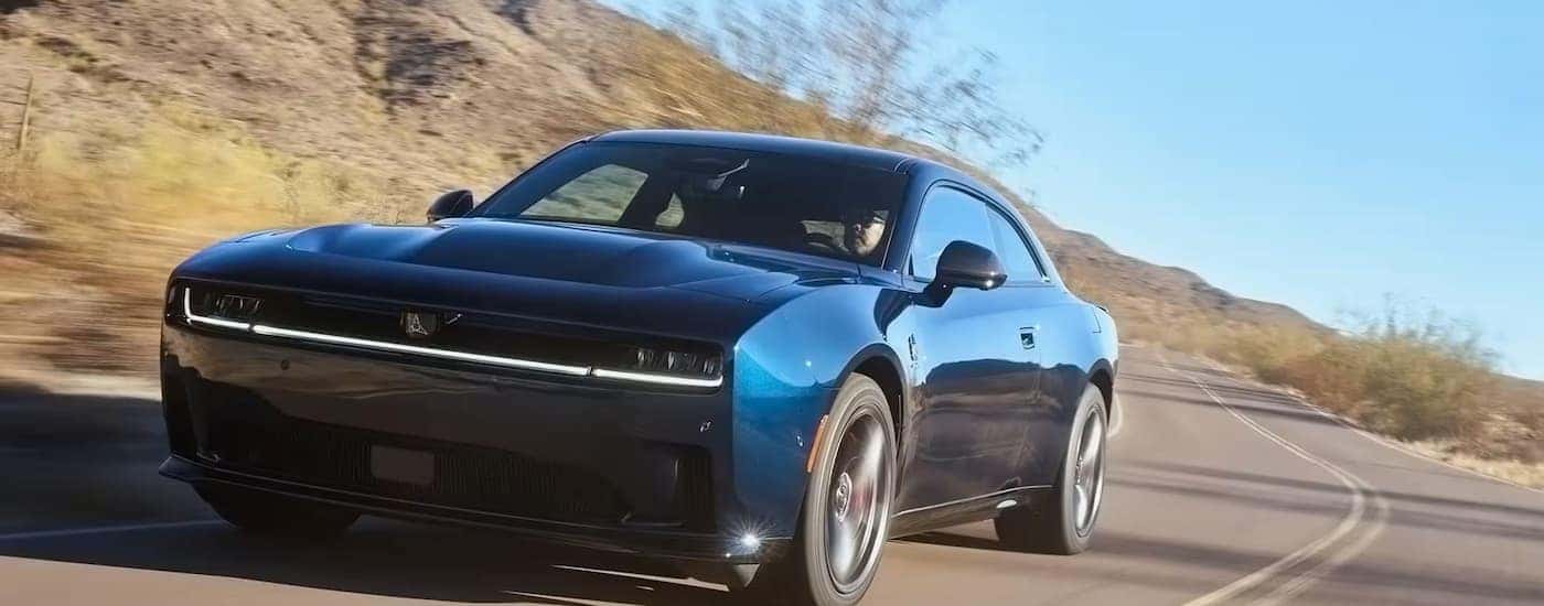 A blue 2025 Dodge Charger driving down a highway
