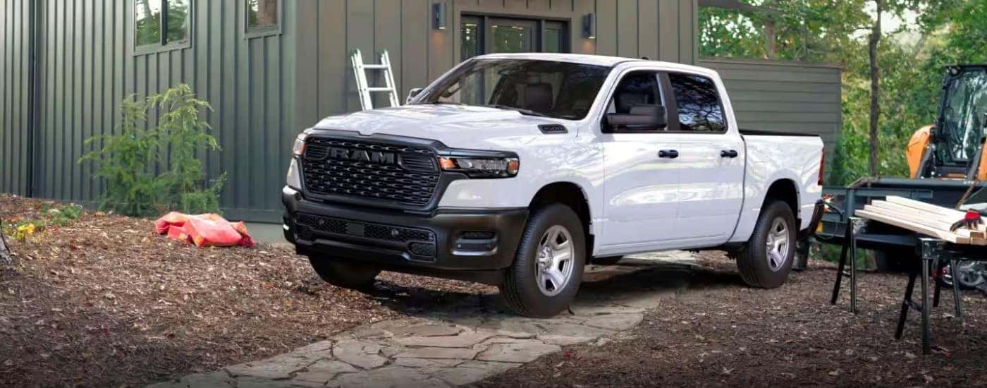 A white 2025 Ram 1500 from the front after leaving a dealer with work trucks for sale.