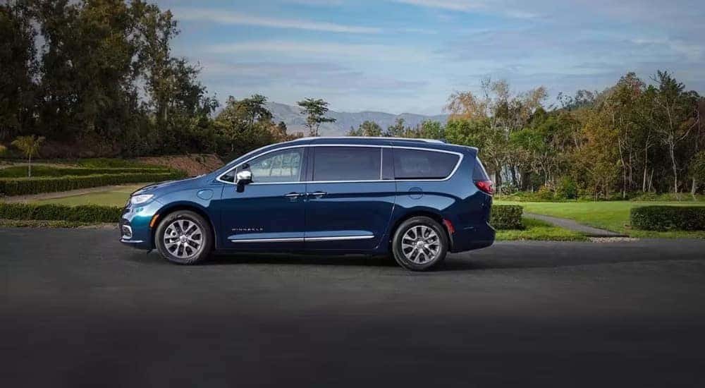 Blue 2023 Chrysler Pacifica Pinnacle Hybrid near a park
