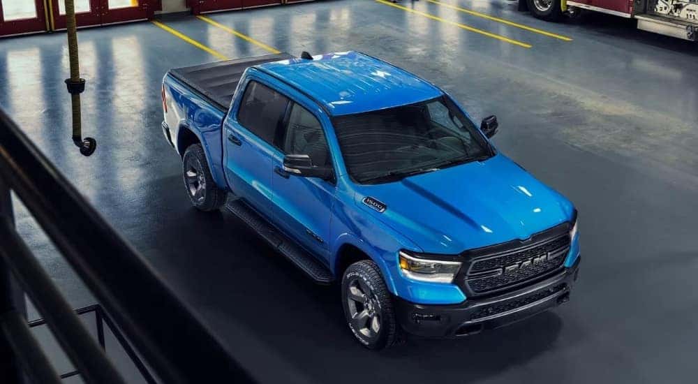 Blue 2023 Ram 1500 Big Horn Built to Serve Edition parked in a fire station