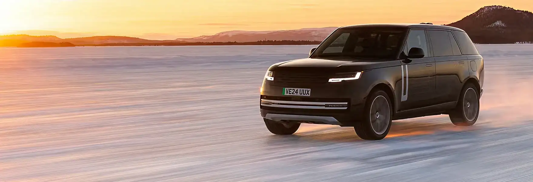 Range Rover Electric on a frozen lake at sunset