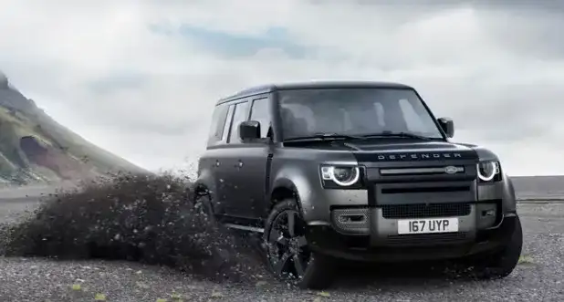 Land Rover Defender equipped with all-terrain tires climbing a rugged off-road trail near Cerritos, CA, showcasing approved Land Rover tires built for rough surfaces.