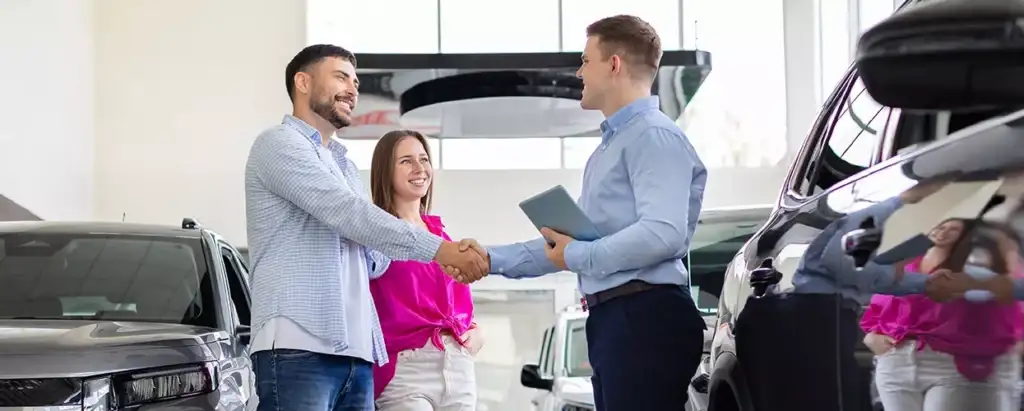 Car salesman talking to a couple about a new vehicle