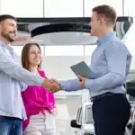 Car salesman talking to a couple about a new vehicle