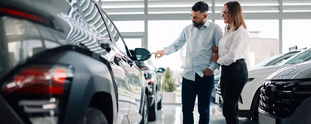 Car salesman talking to a couple about a new vehicle