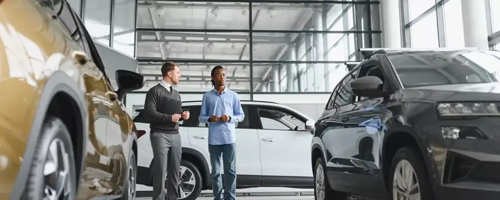 A couple looking at a new vehicle at a car dealership