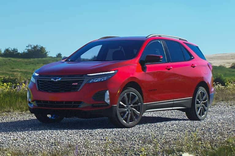 Red Chevrolet Equinox on gravel road