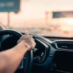 Close-up - Hand of man driving car on the road.
