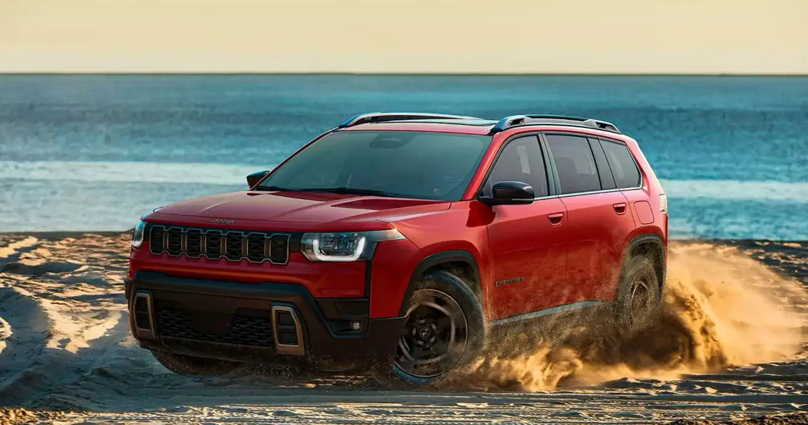A red 2026 Jeep Cherokee on the beach