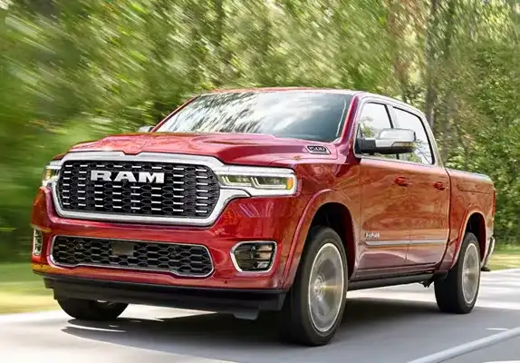 Red 2027 Ram 1500 driving on a tree-lined road