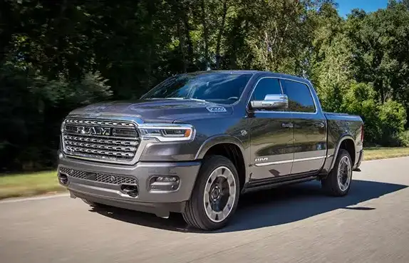 Silver 2027 Ram 1500 driving on a tree-lined road