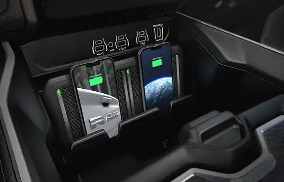 Two phones charging on the dual wireless charging pads of the 2027 Ram 1500