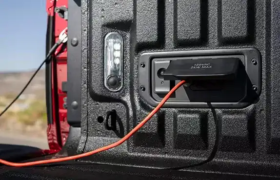 Power outlet in the bed of the 2027 Ram 1500 with a cord plugged in