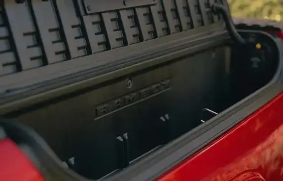 Open RamBox storage bin in the bed of a red 2027 Ram 1500