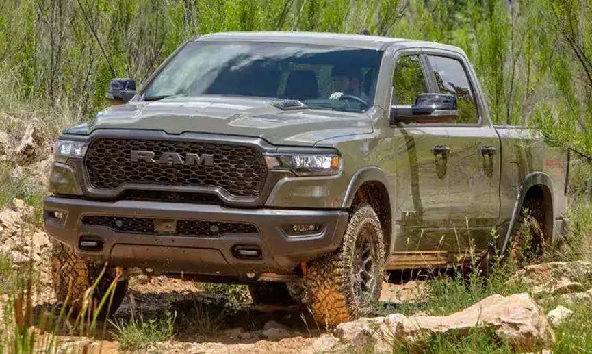Olive green 2027 Ram 1500 on a muddy, rocky trail