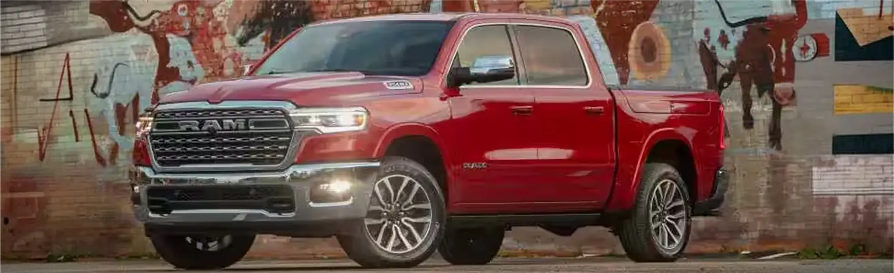 Red 2027 Ram 1500 parked in front of a painted mural wall