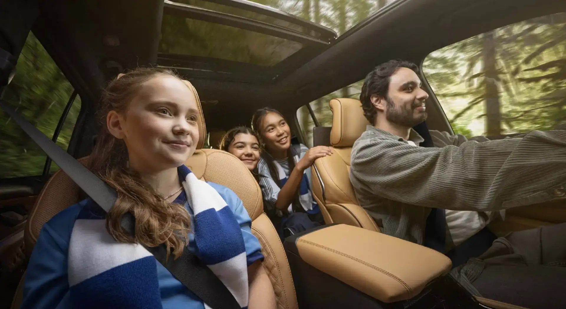 Interior of a Jeep Grand Cherokee with tan leather seats and an open panoramic sunroof
