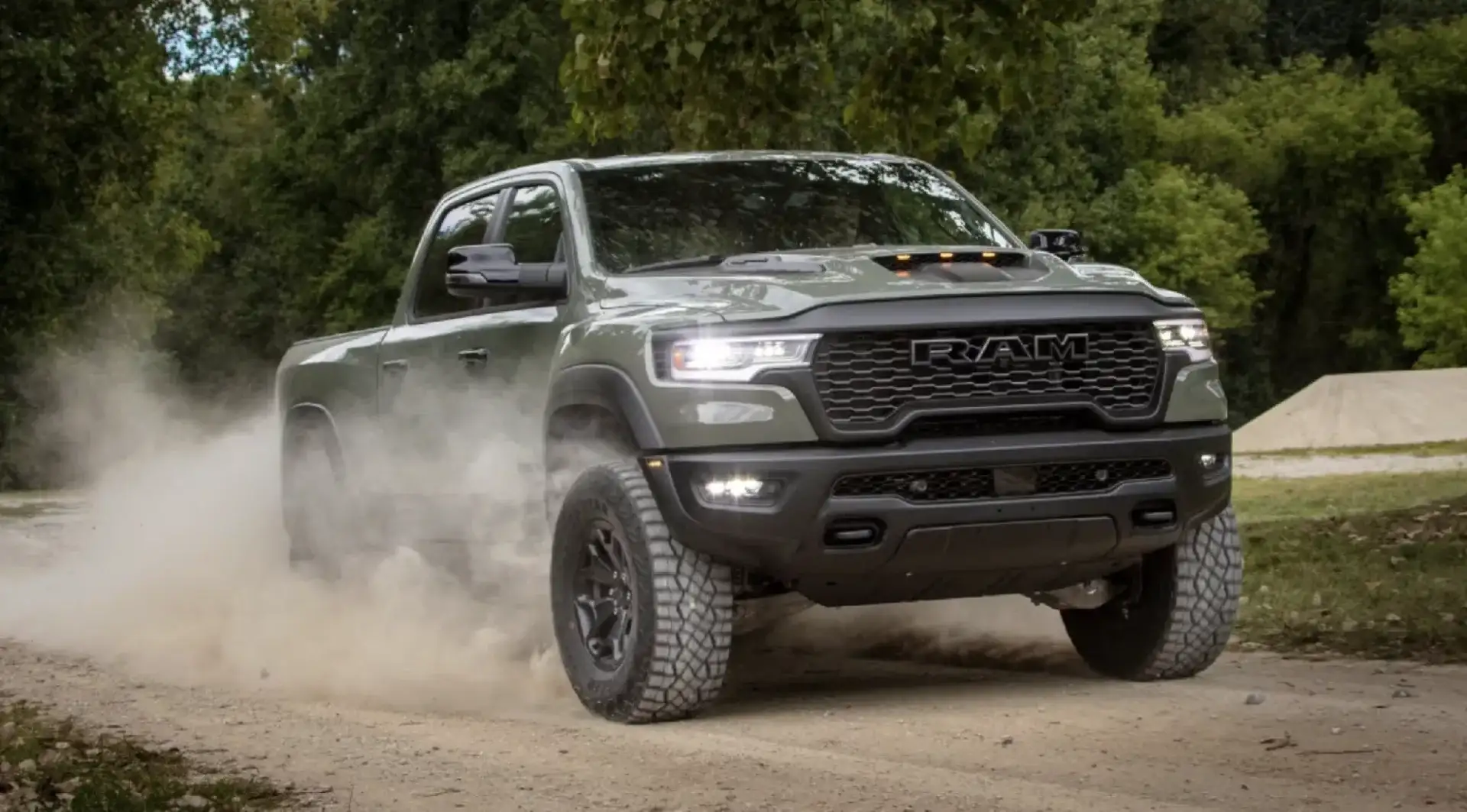 2026 Ram 1500 kicking up dust while driving down a dirt road