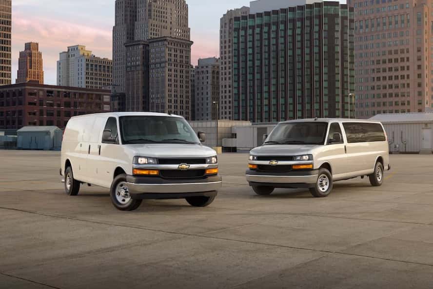 Two white Chevrolet Express commercial vans