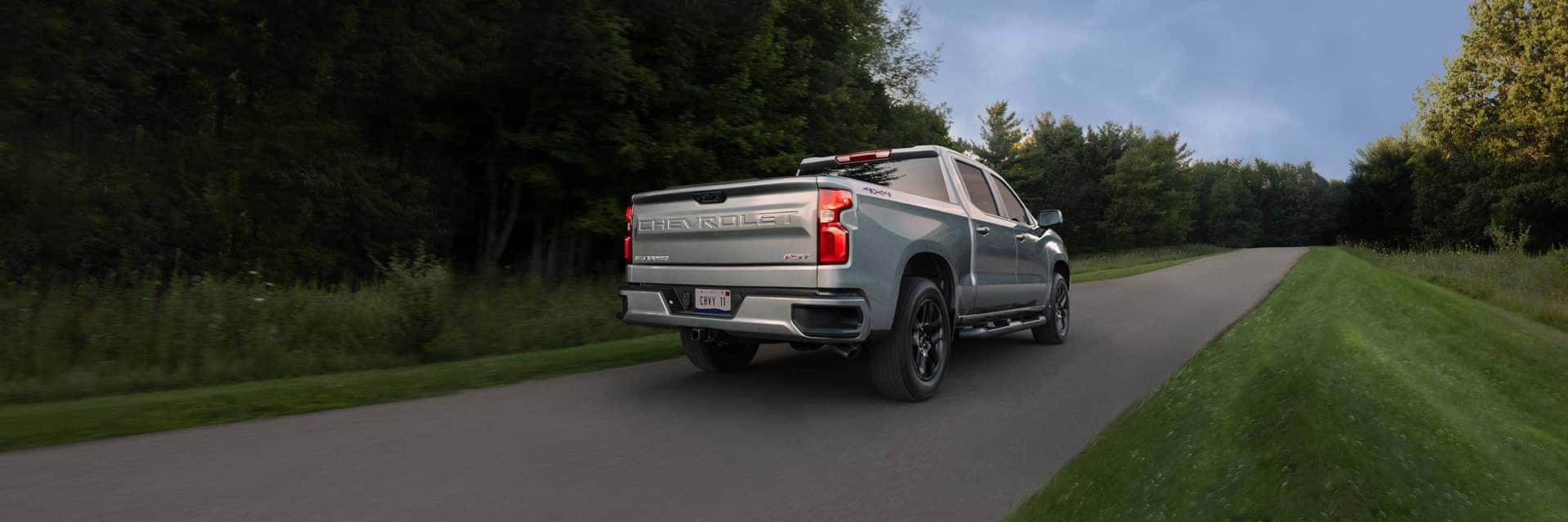 rear view of chevrolet silverado 1500 driving on road