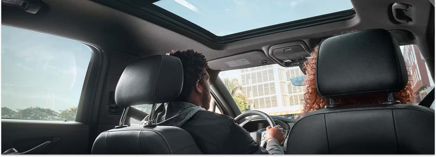 Interior cabin of a 2026 Chevrolet Blazer featuring a panoramic sunroof and black leather front seats.
