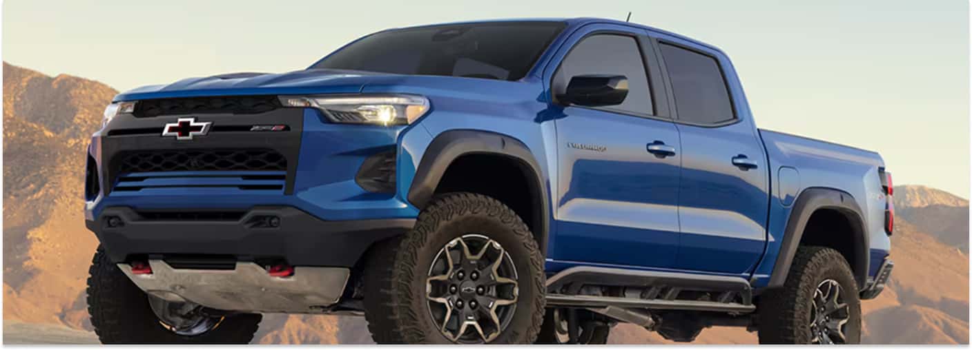 Front three-quarter view of a blue 2026 Chevrolet Colorado ZR2 parked in a desert setting.